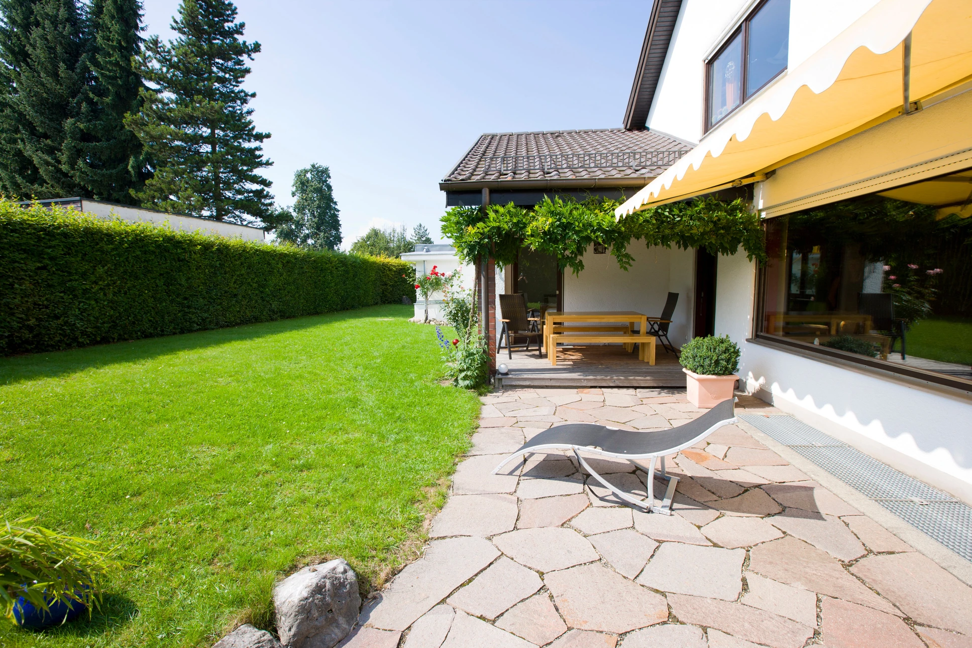 Aménagement paysager extérieur avec murets en pierre naturelle calcaire beige, construction de terrasses étagées et jardinières intégrées